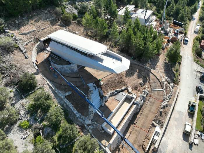 Pumpa za beton dohvaća kuću na padini, snimka iz zraka